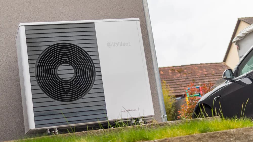 Unité extérieure d’une pompe à chaleur air/eau installée au pied d’une maison