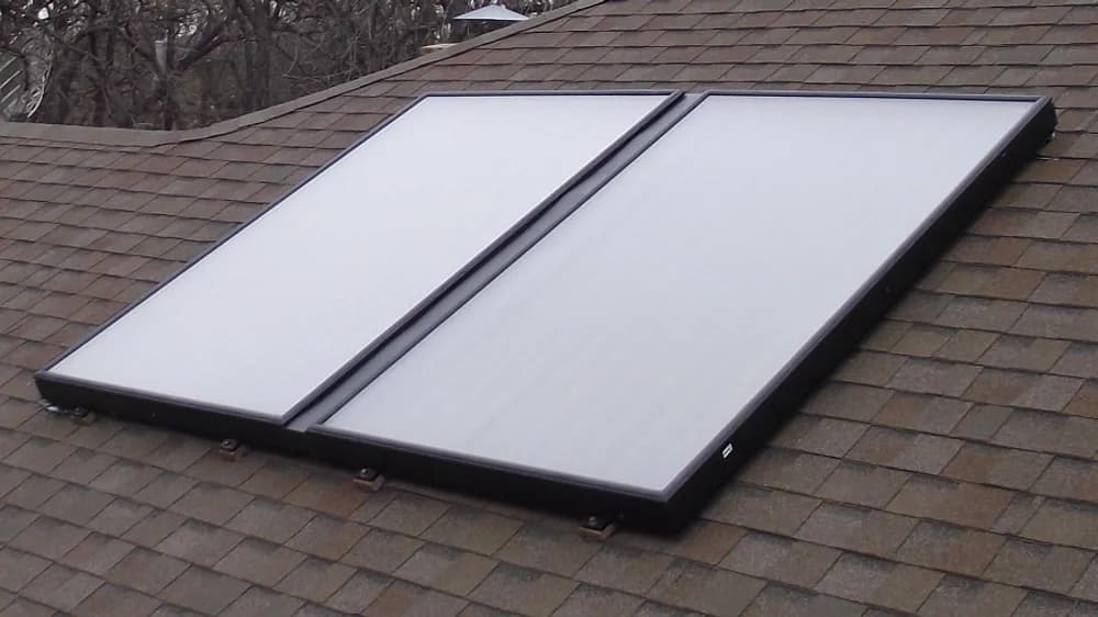 Deux capteurs solaires thermiques plans installés sur la toiture d’une maison